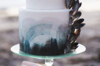 a beach wedding cake in white, with teal, grey and pink brushstrokes and mussel shells attached is wow
