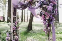 a beautiful lilac and purple wedding arch with lush florals and some airy fabric is amazing for spring and summer