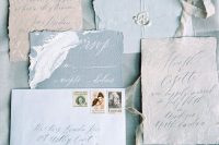 a beuatiful and chic wedding invitation suite with light blue envelopes, a blue RSVP, neutral pieces with botanical prints
