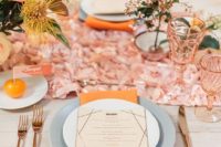 a bold 70s inspired summer wedding tablescape with a pink petal runner, bright napkins, pink glasses and pastel and muted blooms
