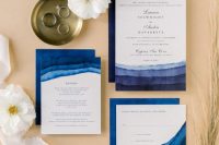 a bold and catchy wedding invitation suite with navy and blue stripes that remind of the sea waves and black and navy calligraphy