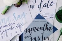 a bright and cool coastal or seaside wedding invitation suite in white and navy, with light blue and navy calligraphy and a navy envelope