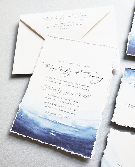 a bright beach invitation suite with blue and navy watercolors that imitates the sea and a raw edge is a very cool idea