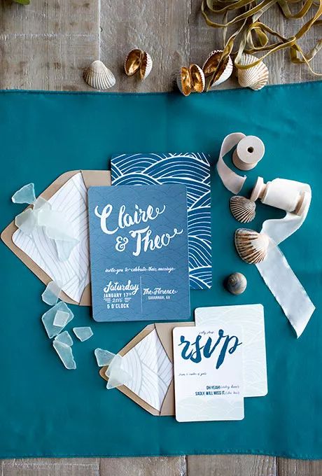 a bright beach wedding invitation suite with blue and white printed and calligraphy invites, with kraft paper envelopes is bold and cool