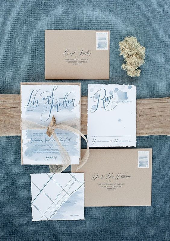a chic beach wedding invitation with kraft envelopes, light blue wedding invites with watercolors and elegant blue calligraphy