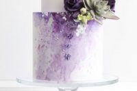 a chic lilac wedding cake with a white tier, an ombre effect, some succulents and sugar blooms