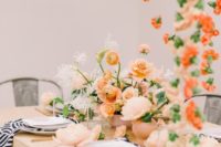 a chic summer wedding tablescape with pastel florals, with zebra print napkins, gold cutlery and lots of blooms hanging over the space