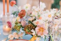 a chic summer wedding tablescape with printed plates, refined florals, colorful candles and succulents