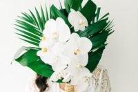 a chic tropical wedding bouquet of tropical leaves, white orchids and a lace wrap for a beach wedding