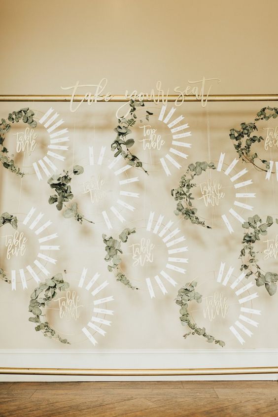 a chic wreath wedding seating chart of wreath froms, eucalyptus and tags is a gorgeous idea