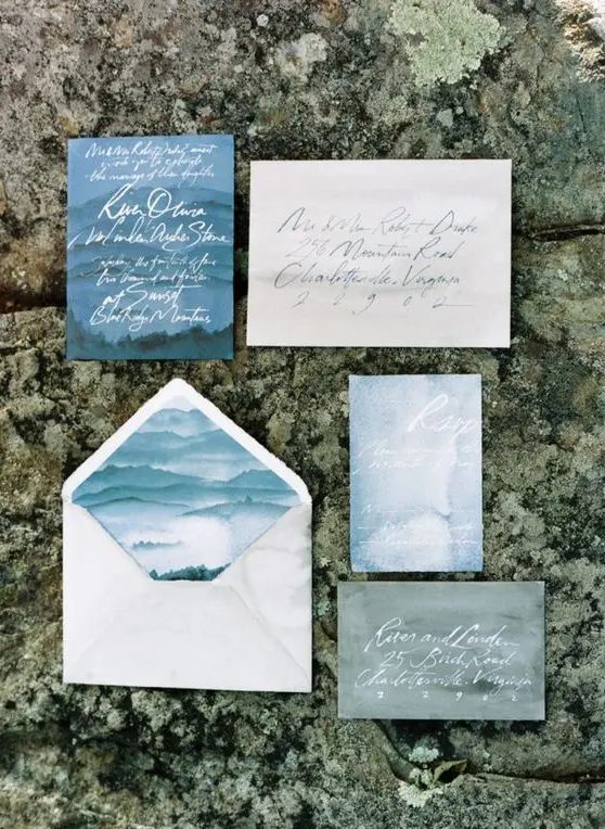 a coastal wedding invitation suite in the shades of blue and greyand calligraphy looks moody and dreamy