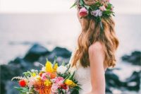a colorful tropical beach wedding bouquet in yellow, coral and red, with much greenery