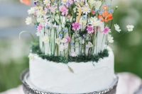 a fantastic wedding cake in white, with tiny colorful flowers, moss and foliage is a lovely idea for a secret garden wedding