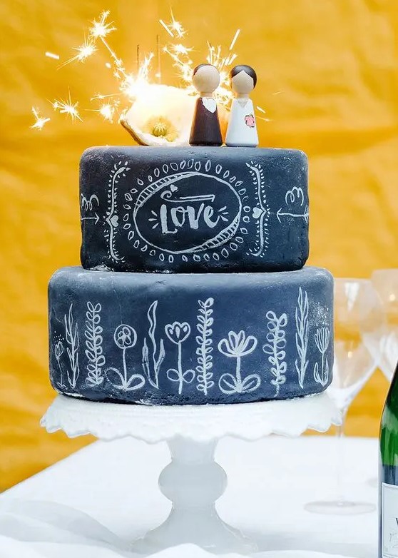 a festive chalkboard wedding cake with chalking and fun kokeshi toppers plus a bit of light is pure fun, it's super cool