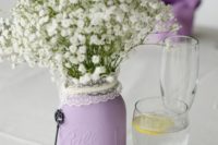 a lilac jar with a lace cover and baby’s breath is a chic and beautiful wedding centerpiece
