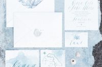 a lovely beach wedding invitation suite in white and light blue, with beach and sea prints, a hand painted map and cool calligraphy and watercolors