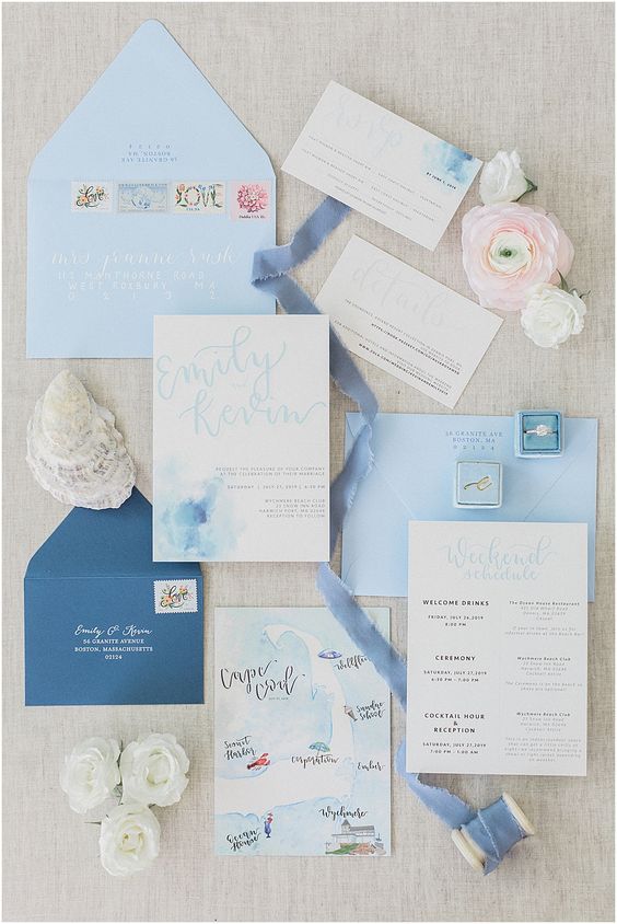 a lovely blue wedding invitation suite with light blue envelopes, a navy one, watercolor blue invites and RSVP