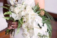 a luxurious cascading beach wedding bouquet of white roses and callas and greenery