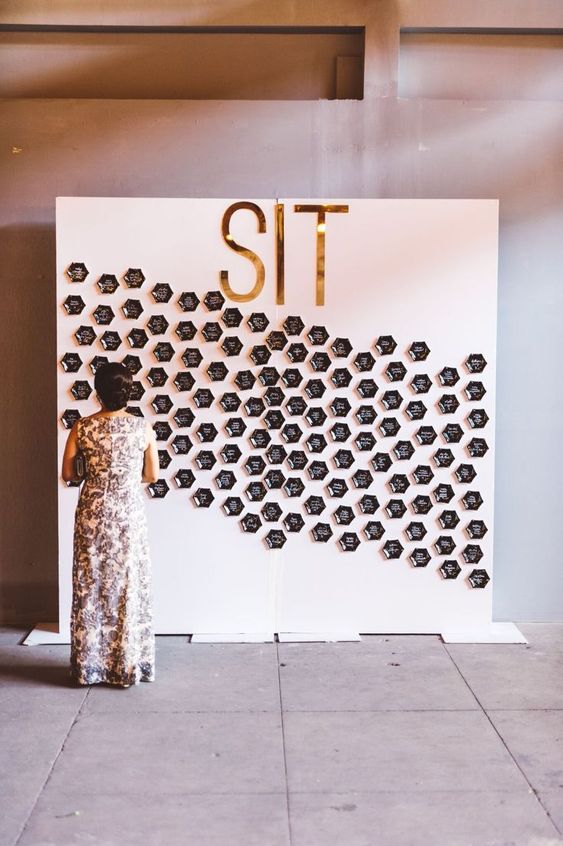 a modern glam seating chart made with shiny black hexagons is a super stylish idea