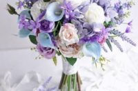 a pastel wedding bouquet with lilac, purple and blush and white blooms and some foliage