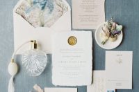 a romantic and chic wedding invitation suite with blush and white invites, a raw edge, bright watercolor botanical prints and tassels