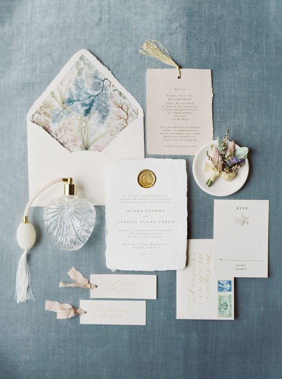 a romantic and chic wedding invitation suite with blush and white invites, a raw edge, bright watercolor botanical prints and tassels
