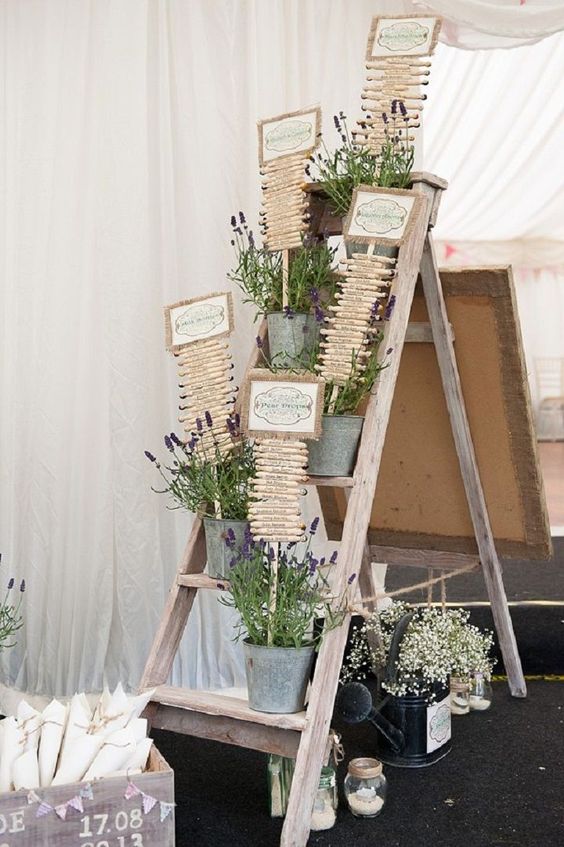 a rustic wedding seating chart done on wooden pegs, with lavender and signs is a chic idea