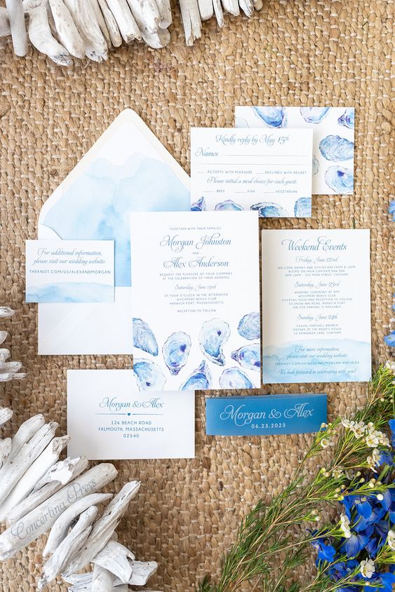 a seaside wedding invitation suite with gorgeous blue watercolors and oyster prints, with blue and white calligraphy