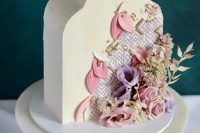 a top forward wedding cake inspired by Middle Eastern Architecture, with pink petals, gold pearls, dried grasses and fresh blooms for a Moroccan wedding