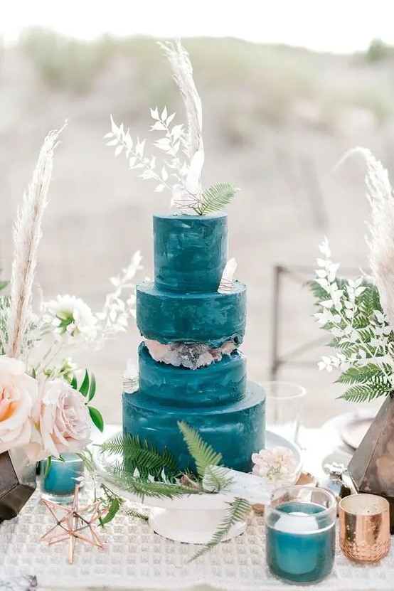 a watercolor teal wedding cake with a geode fault line and some more edible geodes, with white grasses is a bold statement