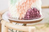 a whimsical wedding cake with color block yarn-like decor for a 70s wedding is a lovely idea with a strong boho feel