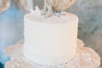 a white beach wedding cake topped with corals and shells plus sea salt mad eof sugar is a lovely idea