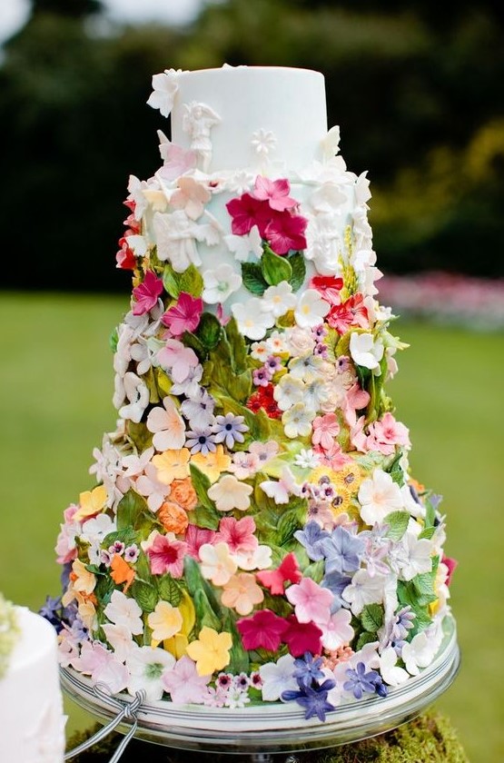 a white wedding cake fully covered with bold sugar blooms and leaves will be a nice solution for a fairy-tale or garden wedding