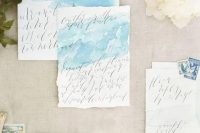 airy light blue watercolor wedding invitations with calligraphy and a raw edge for a seaside wedding
