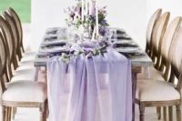 an airy lavender-colored wedding table runner and matching blooms make the tablescape super chic