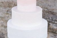 an ombre pink textural wedding cake with a coral on top is a chic and bright idea for a modern coastal or beach wedding