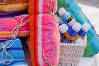 colorful embroidered towels and sunscreen are perfectly useful beach wedding favors to give to your guests