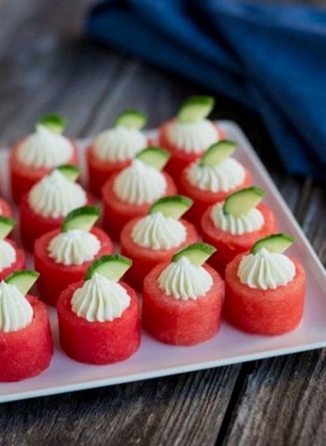fresh watermelon, cream and little cucumber slices placed on top the watermelons are a very creative combo
