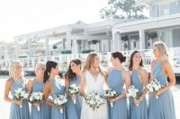 matching blue maxi bridesmaid dresses with halter necklines and pleated skirts for a bright beach wedding