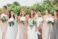 mismatching blush, white and taupe maxi bridesmaid dresses with draped bodices and skirts for a cool beach wedding