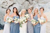 mismatching grey, blue and light blue maxi bridesmaid dresses with draperies for a beautiful and romantic beach wedding