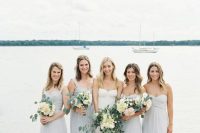 mismatching pale blue maxi bridesmaid dresses with draped bodices and pleated skirts for a pastel beach wedding