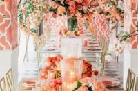 a bright orange, pink and coral wedding reception space with lush florals and candles is amazing for a summer wedding