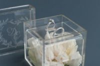 a clear acrylic box filled with white blooms is a cool idea for a modern or minimalist wedding