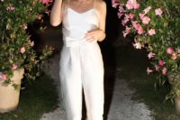 a cute white plain jumpsuit on spaghetti straps, with a bow on the waist and bow heels