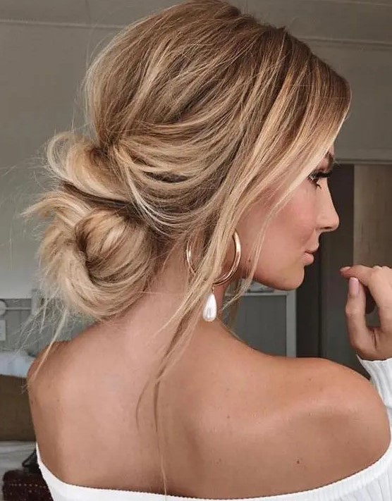 a lovely messy and wavy low updo with a volume on top, some locks down and a twisted low bun is a gorgeous idea for a modern bride
