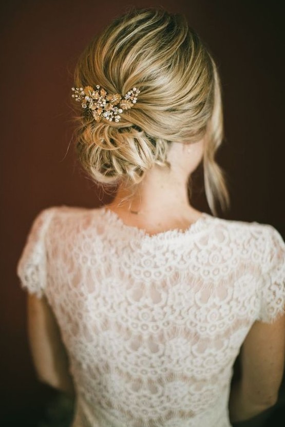 a messy low bun with a bump and a bead and rhinestone hairpiece plus some locks down