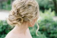 a messy wavy and twisted updo for an effortlessly chic bride, such an updo cna be worn with long or medium length hair