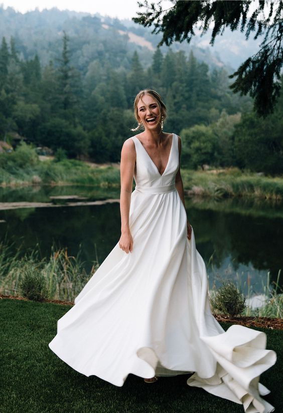 a minimalist wedding ballgown with a plunging neckline, thick straps and a train for a modern romantic bride