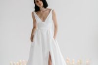 a minimalist wedding ballgown with thick straps, a deep neckline and a front slit plus a train
